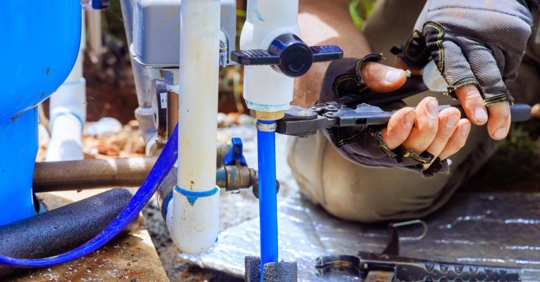 Pipe being connected to water supply artesian well system pump house